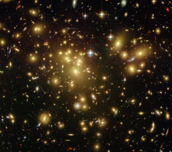 Hubble image of a cluster lensing a background galaxy explained in text