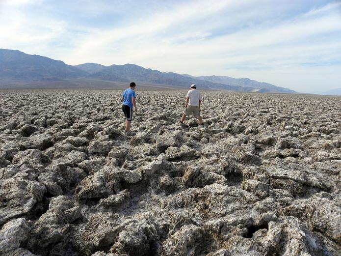 People walking on the rough surface of evaporite mineral halite (NaCL) formed in Death Valley, California