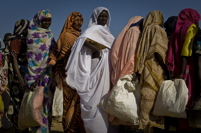 Refugee women standing in food line.
