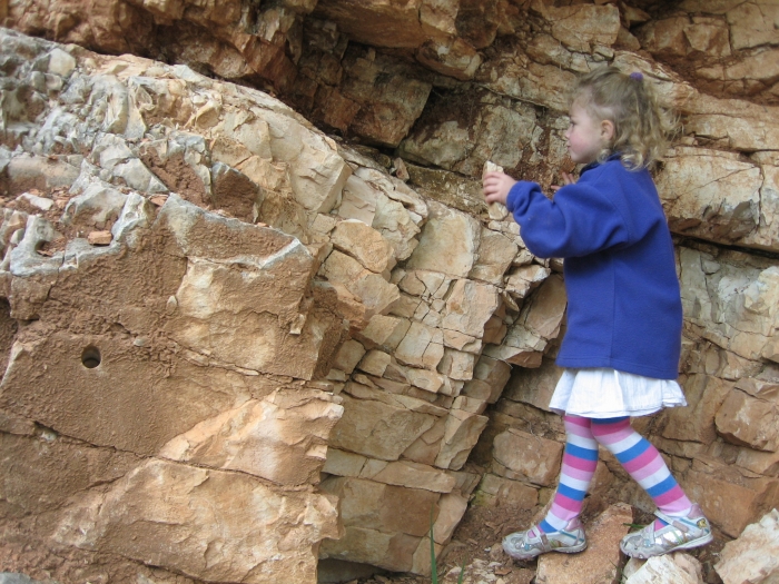 small girl playing with loose rocks at the K/T boundary
