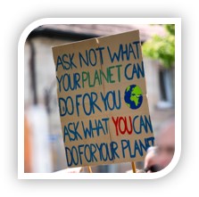 a protester's sign which reads, "Ask not what your planet can do for you, ask what you can do for your planet"