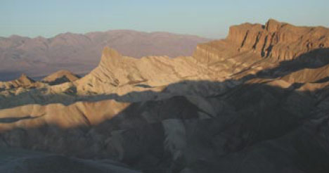 A mountain range with foreground in shadow.