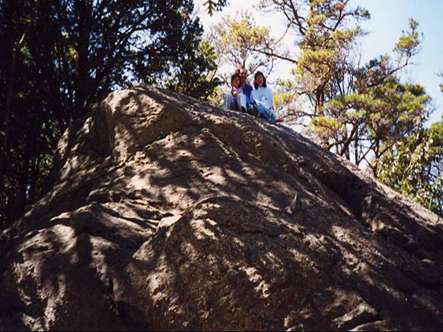 Family of three sitting atop Great Rock