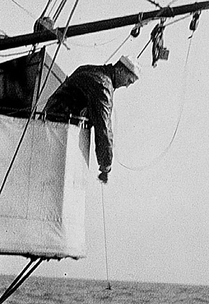 Black and withe photo from 1916 of a Seaman paying out a sounding line during a hydrographic survey 