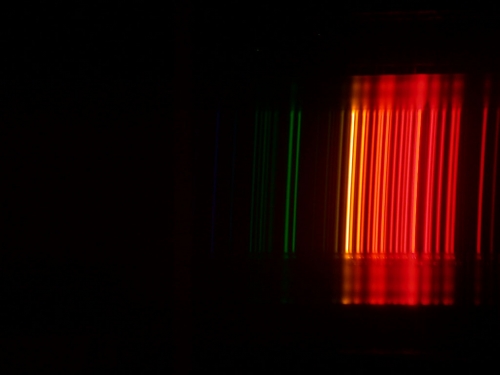 Spectrum created when you pass light from a neon containing bulb through a diffraction grating, showing many emission lines in the red and orange part of the spectrum.