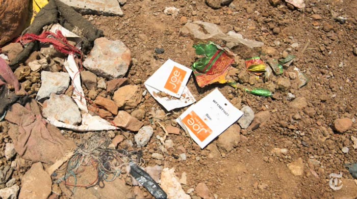 screenshot of clothing labels among building rubble