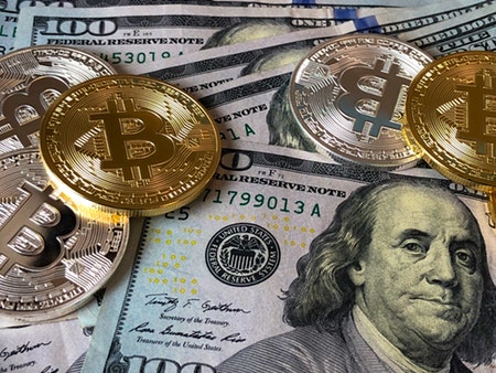 $100 bills and Bitcoins