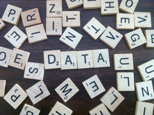 Scrabble game tiles laid out on a table with some spelling the word data