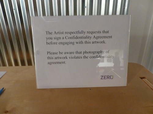 Sign requesting that viewers of artwork must first sign a confidentiality agreement