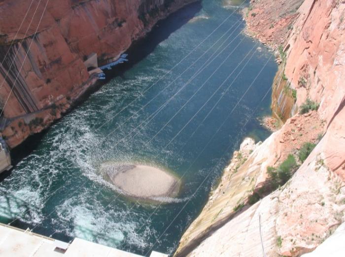 Power lines that carry electricity away, stretched across the water.