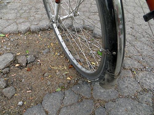 Wheel of bike inside a pot hole.