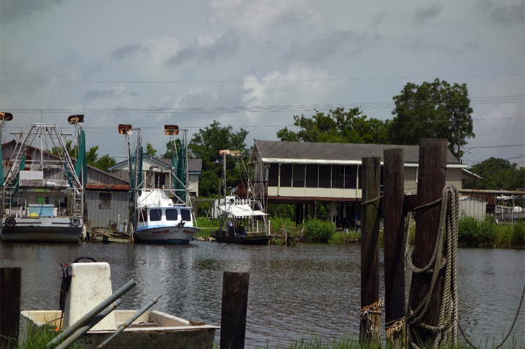 View from the water of the boats and houses on the Isle de Jean Charles 