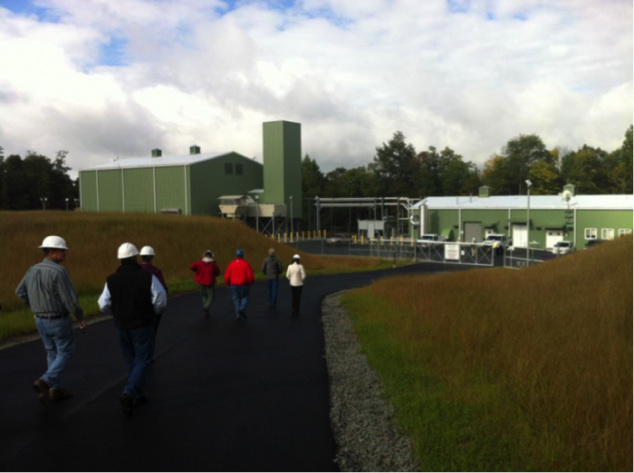 Workers in hard hats walking into a compressor station