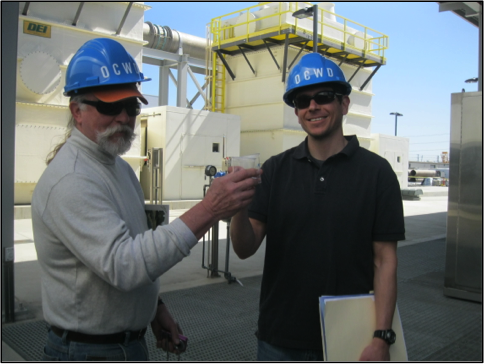 Two professors sampling the treated water at the treatment facility.
