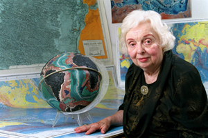 marie tharp with some of her maps in the background