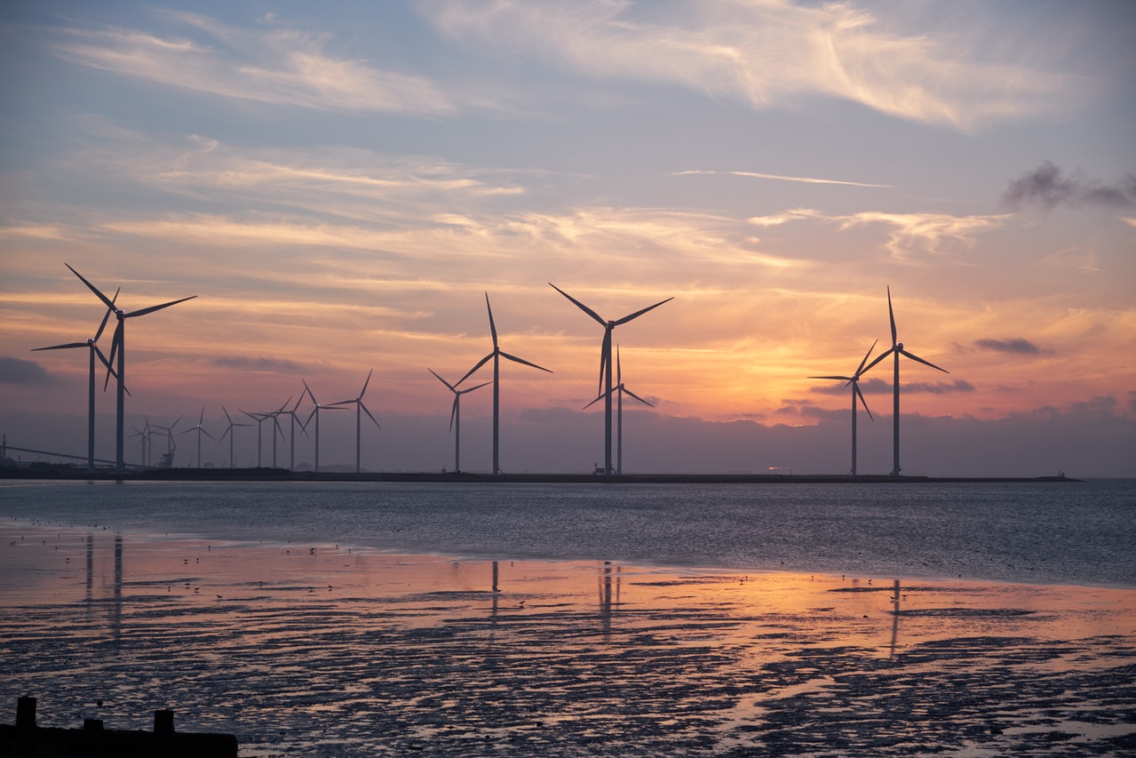 A field of large, modern windmills reflecting on water