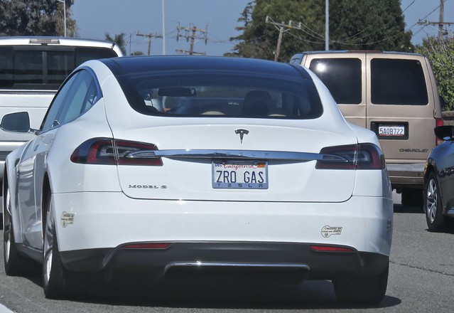 Rearview of a white Tesla Model S car with a license plate that reads "ZRO GAS"
