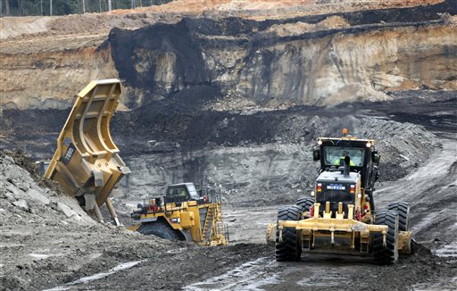 An earth mover and a dump truck working in a lignite pit.