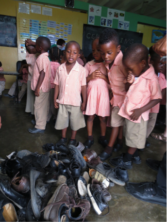 example of re-distribution programs. pile of shoes surrounded by orphanage children