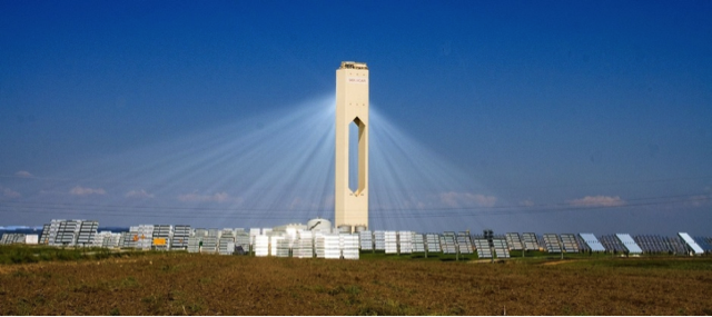 Solar Panels in A field surrounding a solar tower