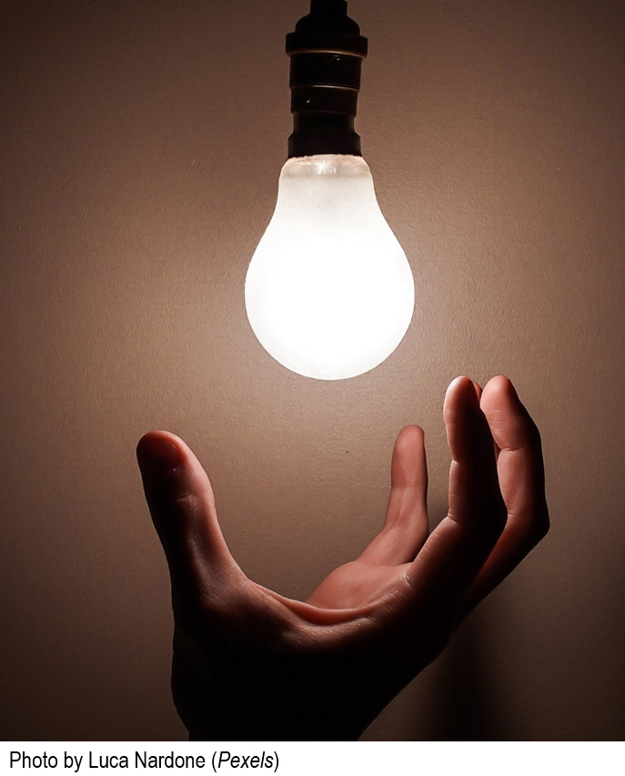 Hand reaching for light bulb