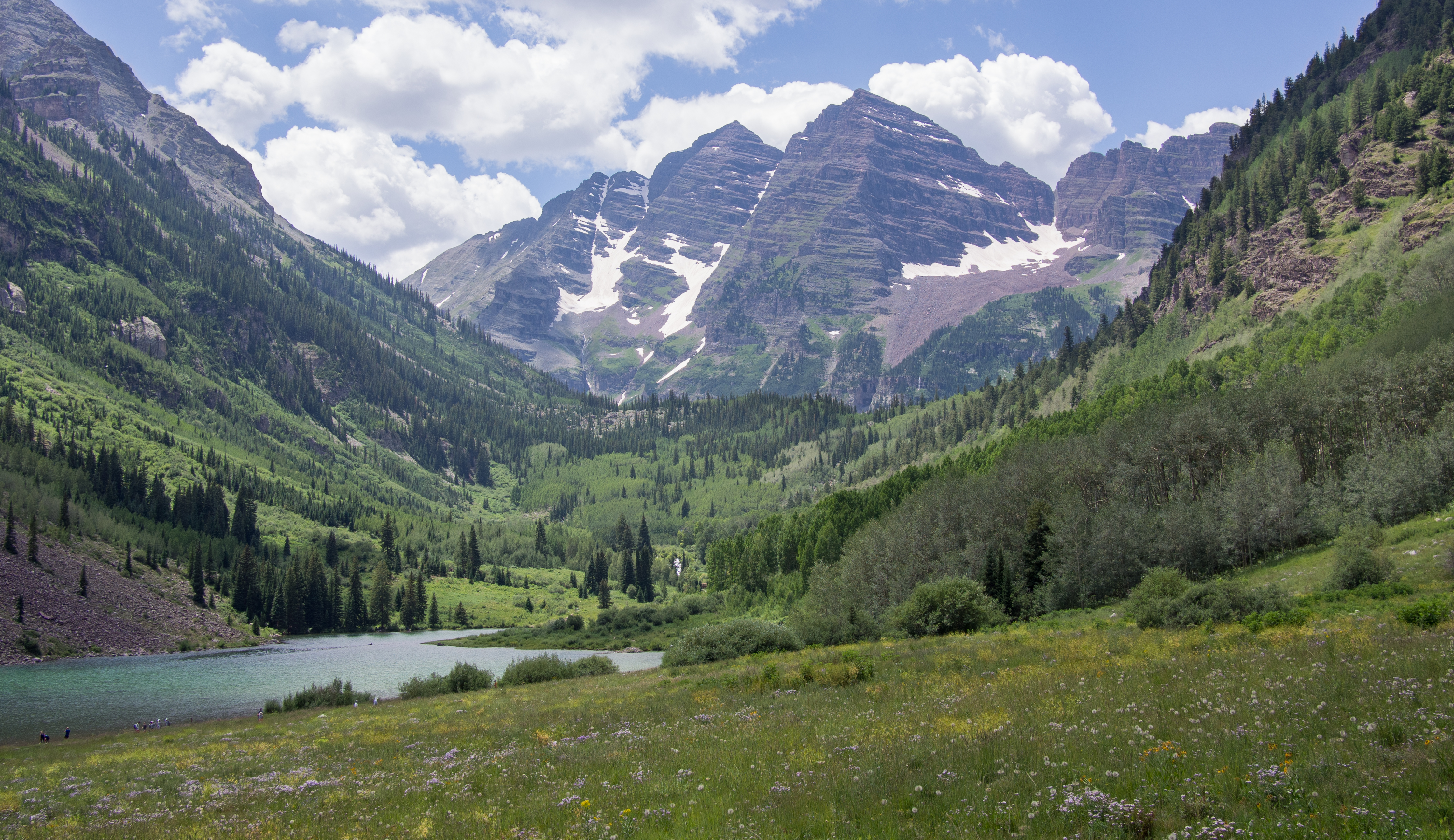 mountain peaks and trees surrounding small lake