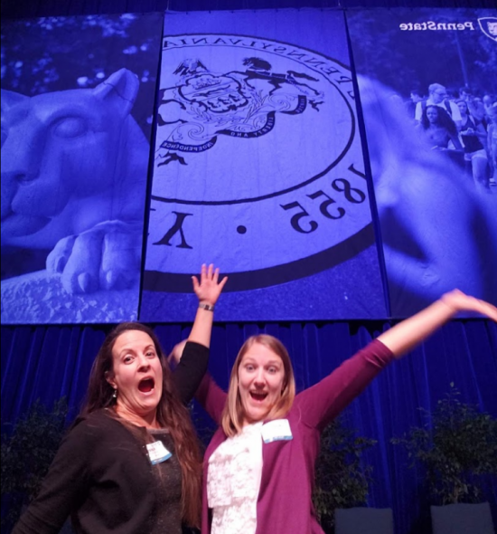Brandi and Haley in front of PSU banner at graduation. 