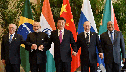 BRICS leaders meet on sidelines of G20 in China. Standing hand-in-hand in front of respective flags. 
