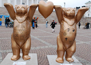 Statue of two golden bears standing on their back legs holding a heart between their hands