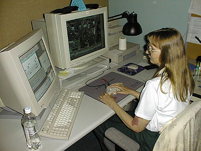 Photograph of Merri MacKay using an analytic stereoplotter. More in surrounding text.