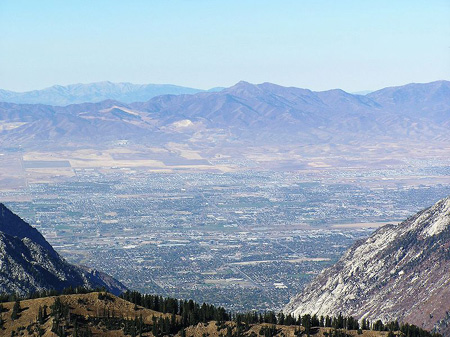 Overlook from Snowbird's Hidden Peak, Salt Lake City of city, trees, and mountains.