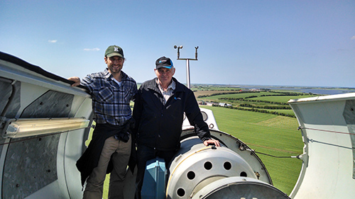 two men standing in nacelle of wind turbine
