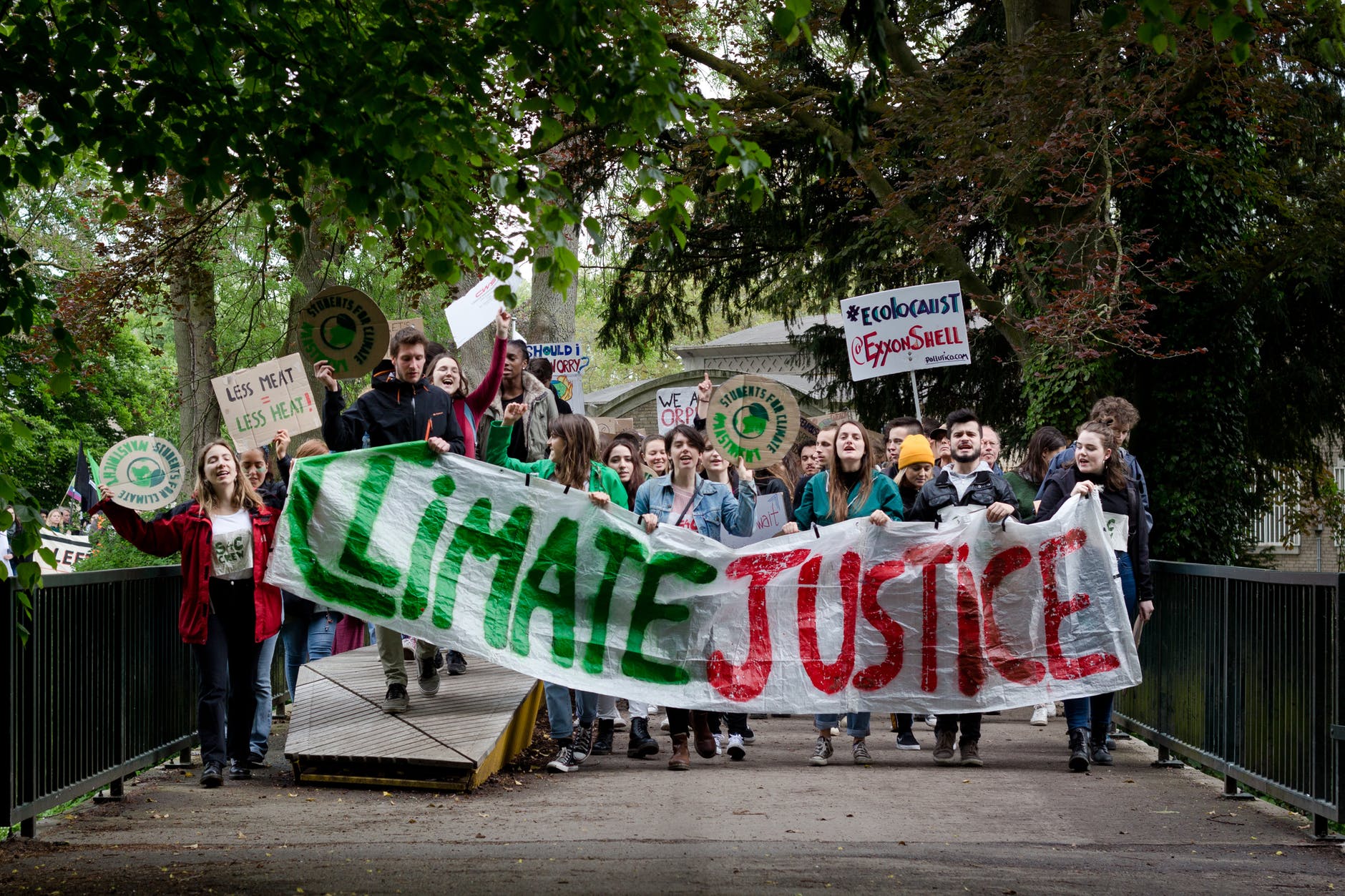 young adult protesters with a large climate justice banner