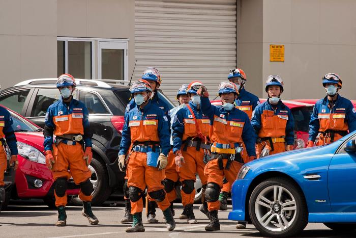 Search team in orange jumpsuits preparing to enter an area