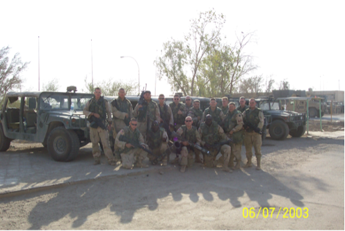 platoon of soldiers in Iraq posing in front of vehicles