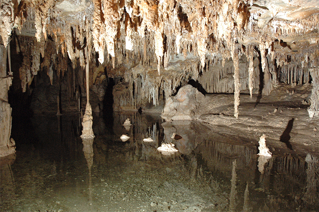 Water in a cave with stalagmites and stalagtites