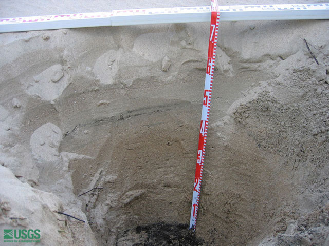 A 2 ft deep hole in the sand.  The sand was found inland.  It was relocated from the shore to Lampuuk by the  tsunami.