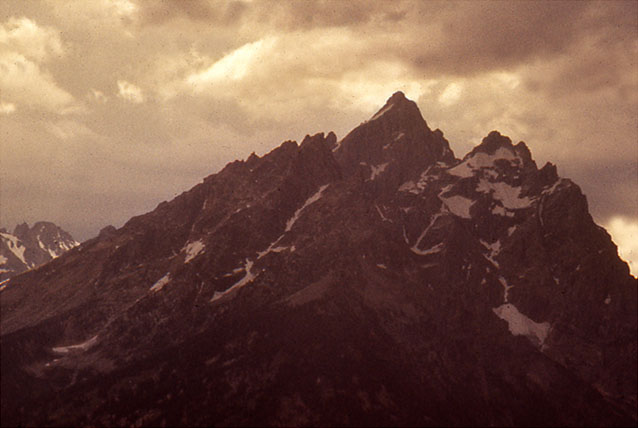 Close-up of Grand Teton peaks with dark thunder clouds above
