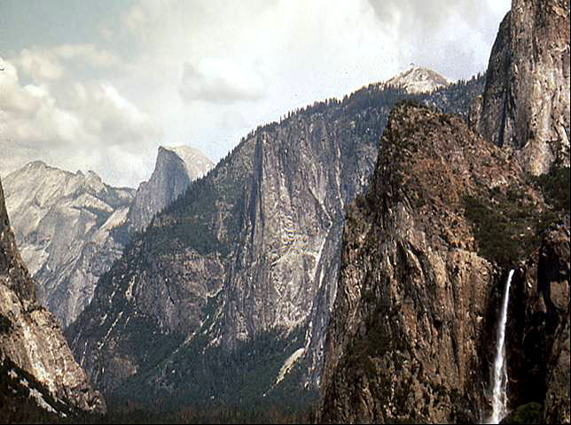 Yosemite valley under cloudy skies. Bridalveil Falls in the foreground to the right.