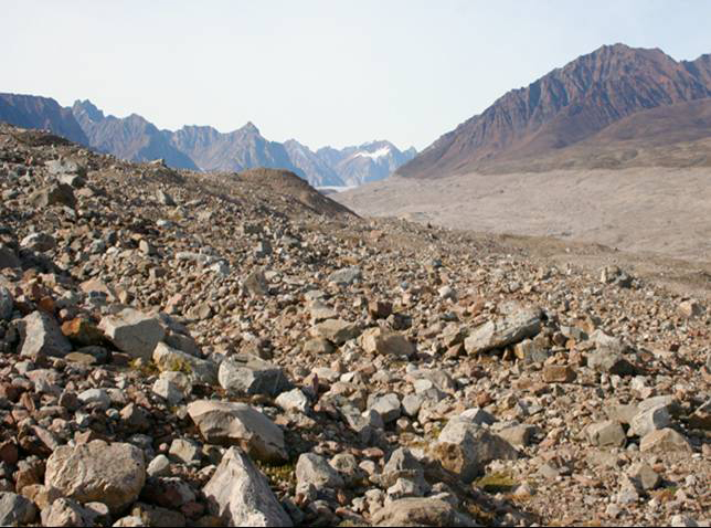 Deposits of Bjornbo Glacier, NE Greenland National Park.  Rock pieces in foreground and mountains in background.