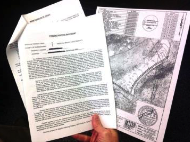 hand holding an easement agreement and map of the property
