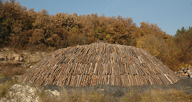 log pile to be burned to become charcoal