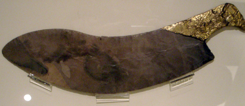 large, old, brown flint knife with golden handle