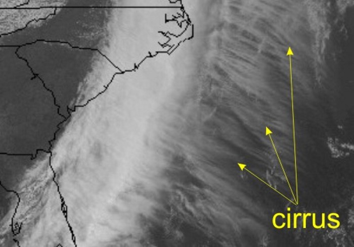 Comparatively thick coastal clouds with wisps trailing to sea.