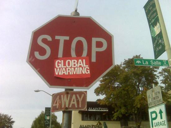 Image of a stop sign with a red global warming sticker on it