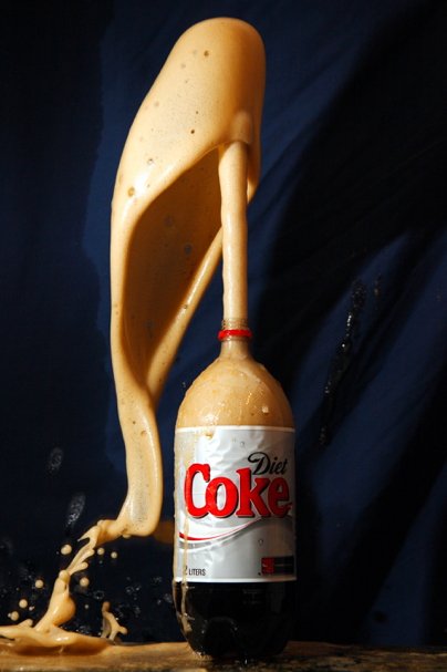 2 liter Diet coke bottle erupting - foam spewing out the top like a volcano.